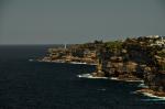 Členité východní pobřeží Austrálie lemující Sydney. Čnící falus na útesu v pozadí není ani maják, ani strážní věž...