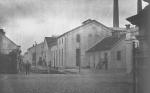 Historická fotografie - kolem r. 1920. Budovy cukrovaru. Komín vlevo. 