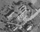 Letecký snímek z roku 1953. Fabrika už tehdy rozpadající, komín stojí solitérně uprostřed obrázku (z kontaminace.cenia.cz)
