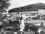 Nedatovaná fotografie zobrazující fabriku s komínem, v popředí doubický kostel. Poskytl František Sajdl
