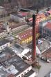 Historický snímek kompletního komína. Za povšimnutí stojí dnes již zmizelá neonová loga na věži fabriky, prvorepubliková dostavba jídelny (za přechodem) a nýtovaný mostek přes Otavu vyrobený r. 1892 ve Vojtěšské huti.